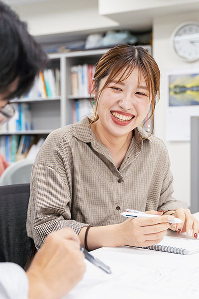 笑顔でメモをとる写真